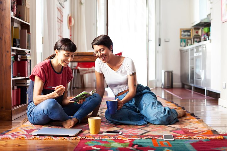 Two adults on floor smiling and talking together