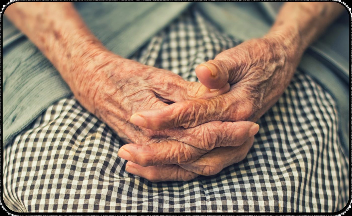 Elderly person's hands folded on lap, representing the beauty of aging gracefully with wisdom.