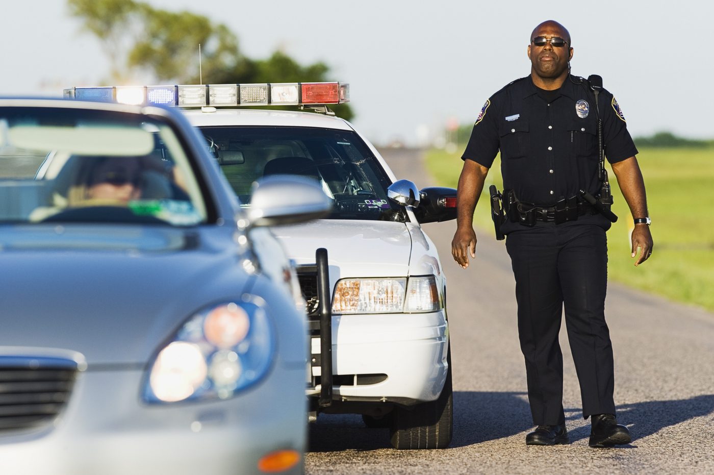 Police officer walking toward another car