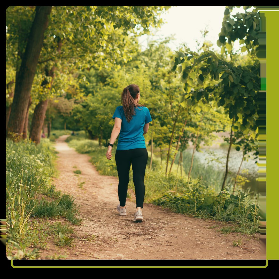 Active young woman is walking on a path in the forest on daytime.