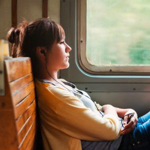 girl on train listening to music