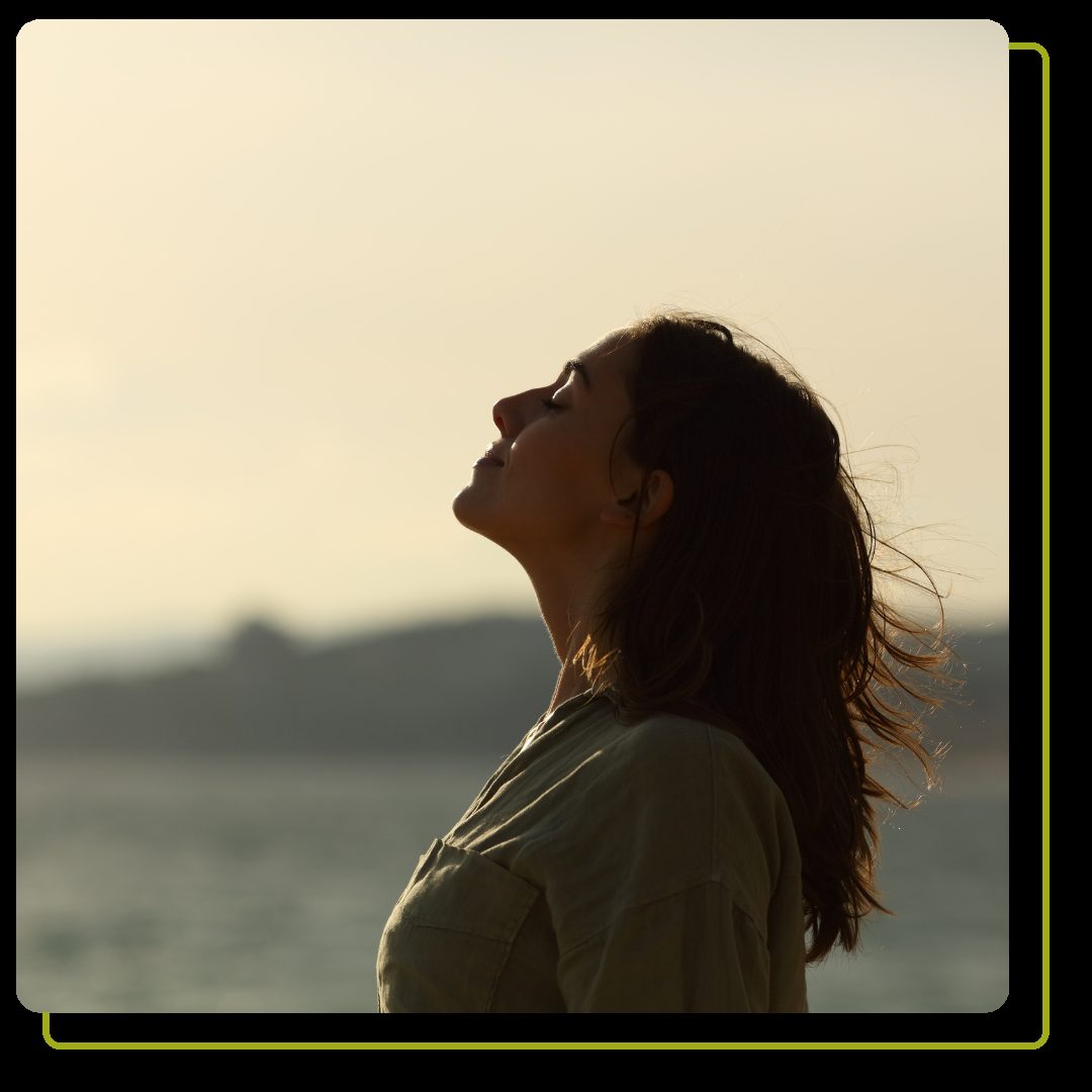 woman silhouette breathing fresh air on the beach