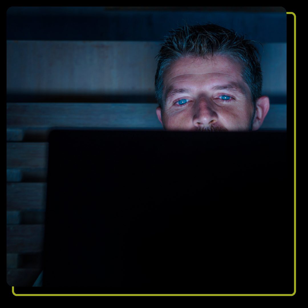 man watching computer in a dark room