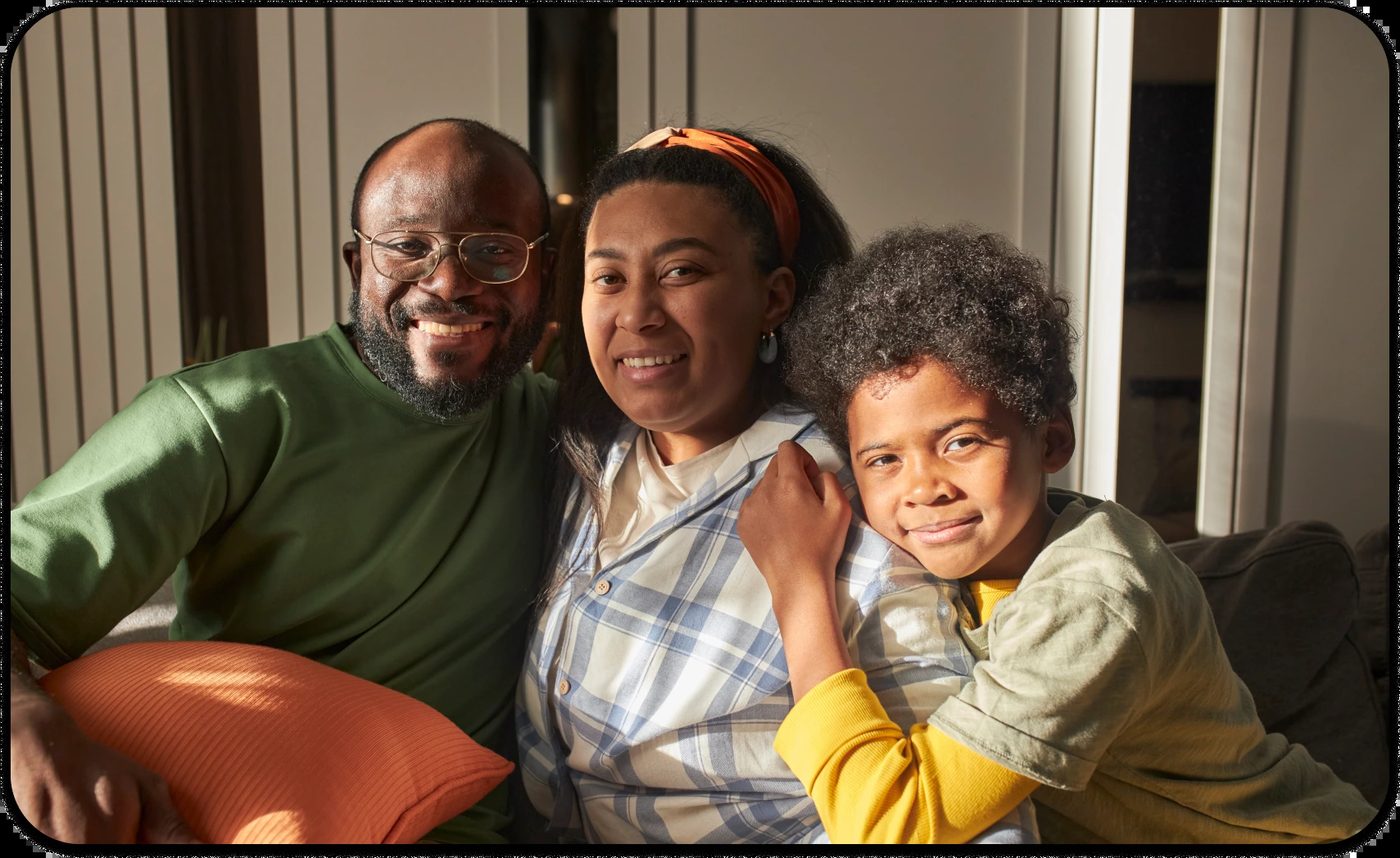 Black family smiling together at home, showing love, unity, and breaking Black mental health myths.