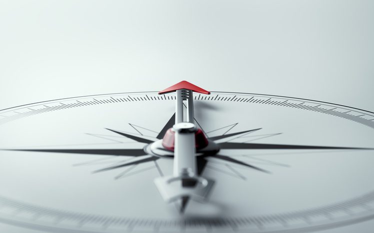 Compass on white background with selective focus.
