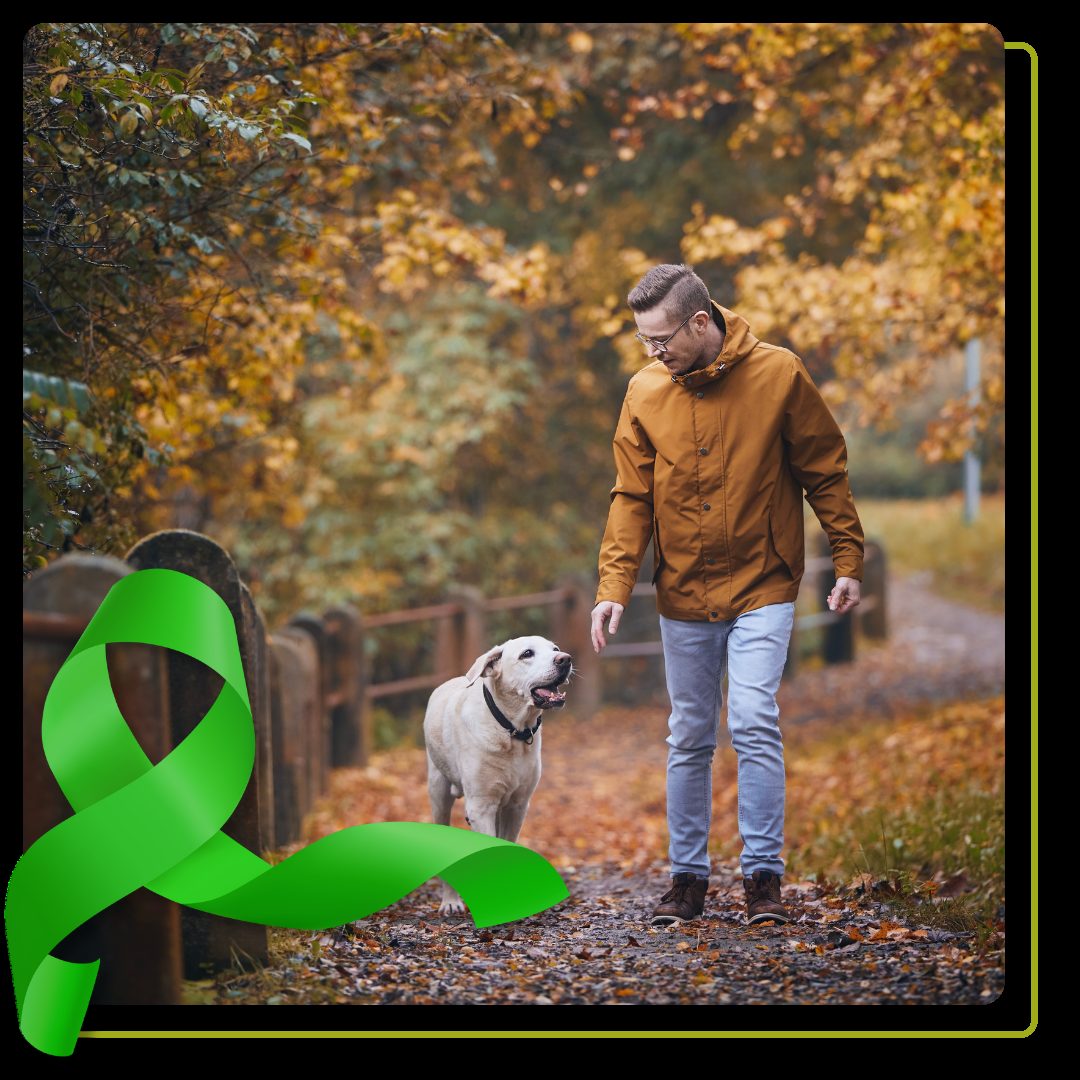 man walking with his dog with orange leaves on the ground