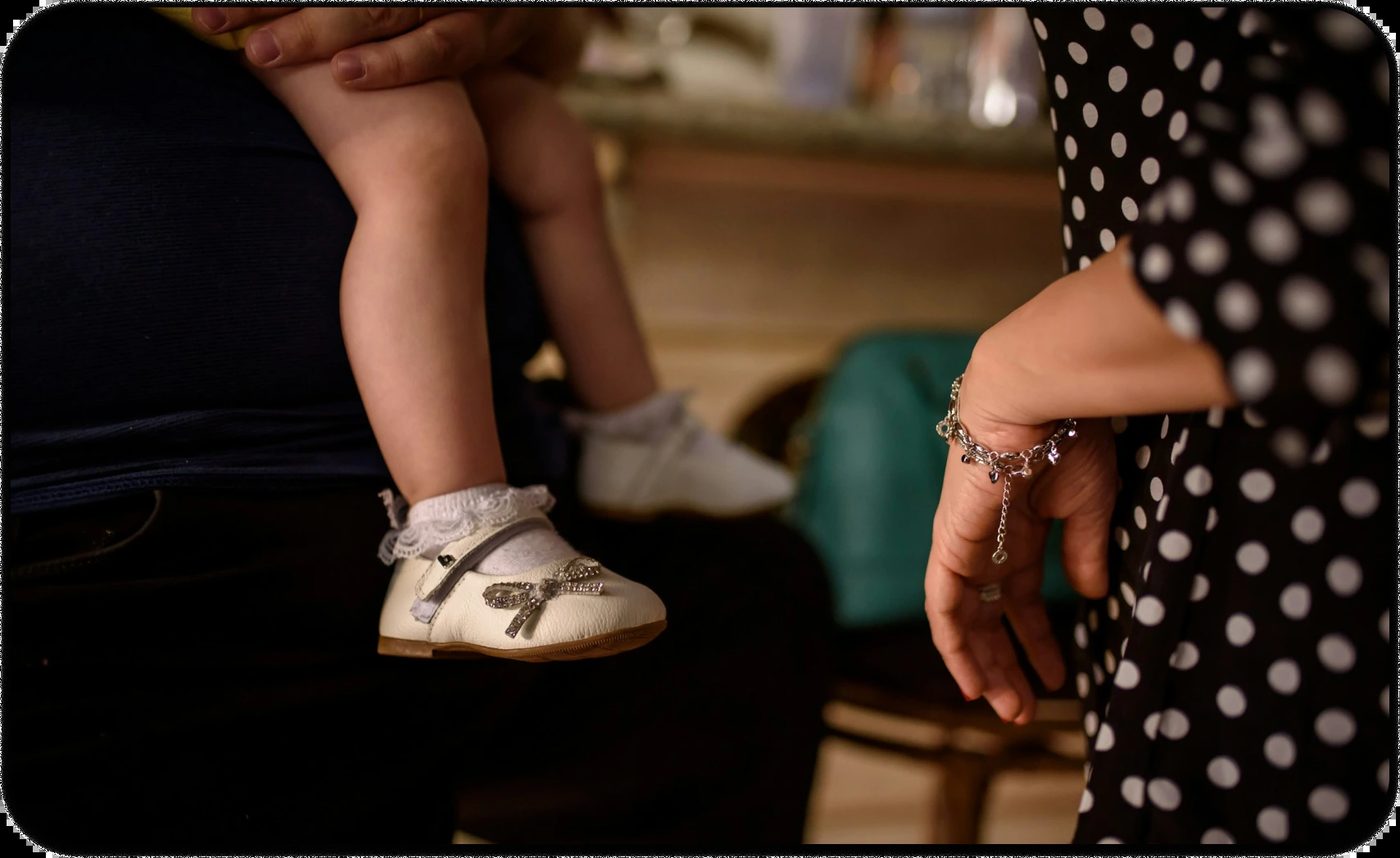 A child being held while two parents stand nearby, symbolizing co-parenting with a narcissist.