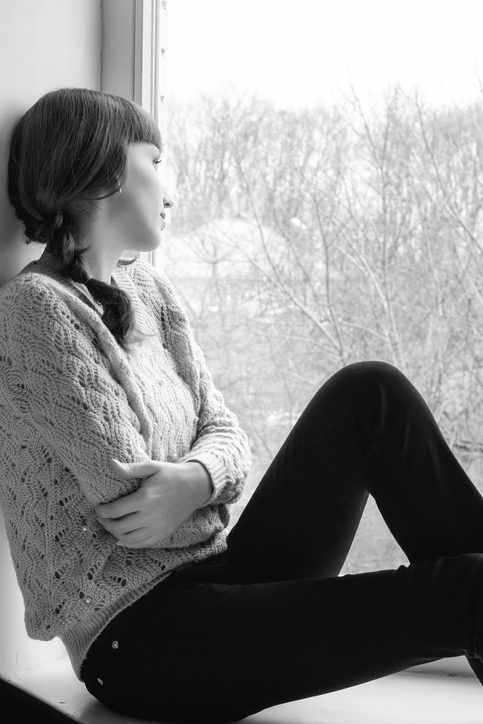 Arms to chest, staring out window