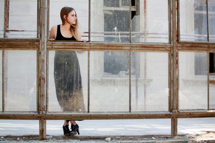 Person stands against row of old windows