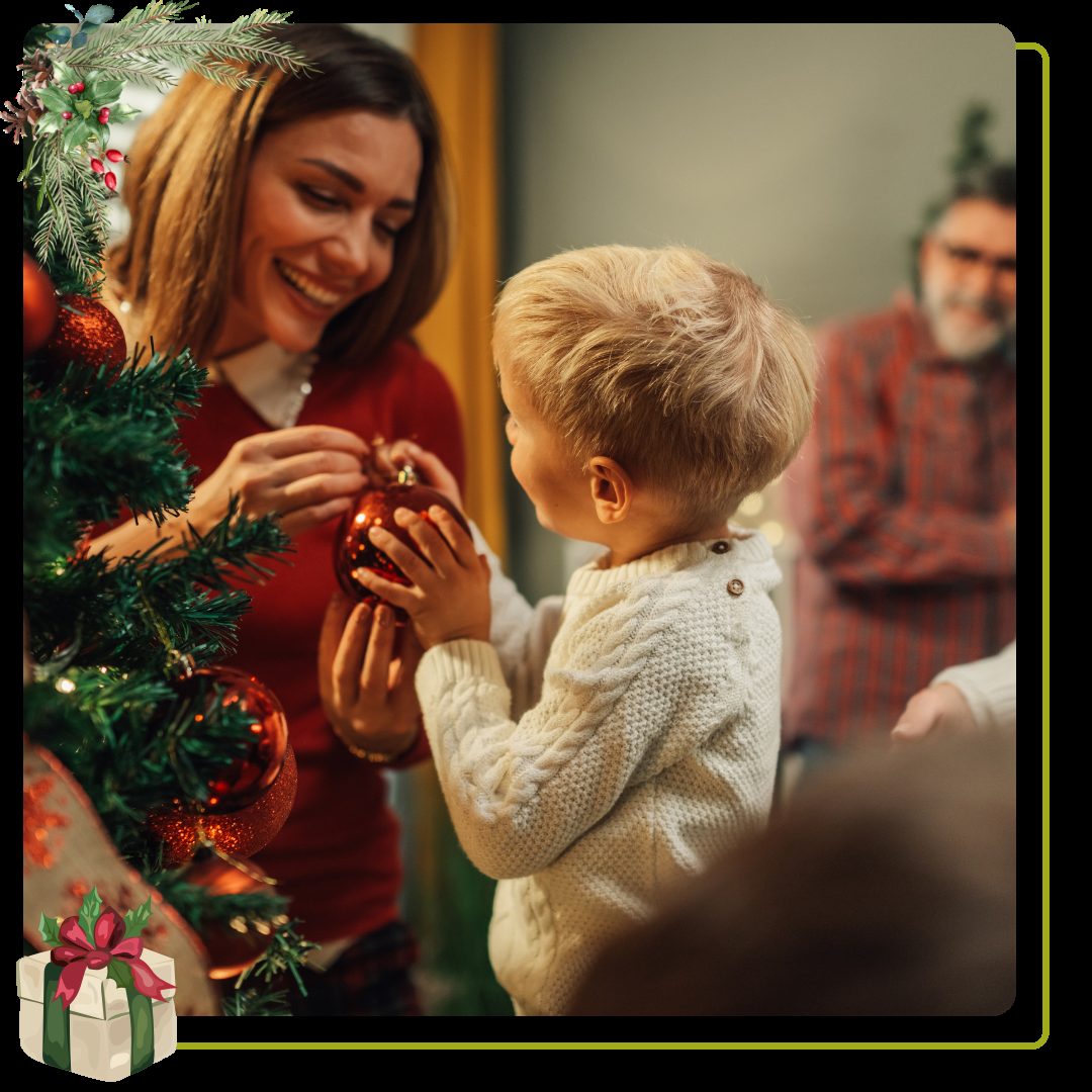child and woman decorating Christmas tree with ornaments