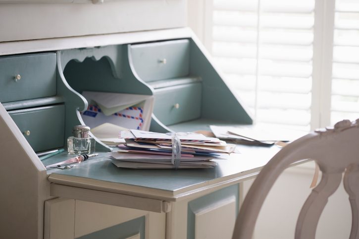 A stack of photos tied with ribbon on blue and white writing desk