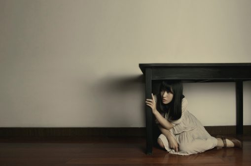 Girl hiding beneath the table