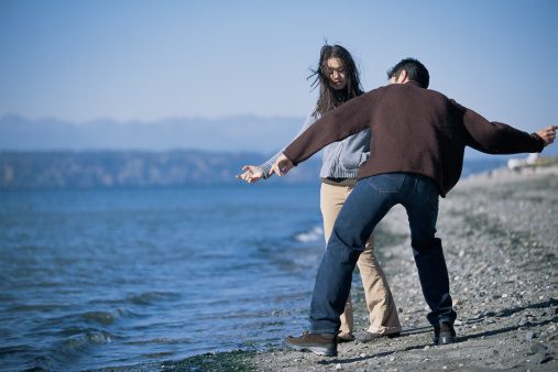 Father and daughter skipping stones