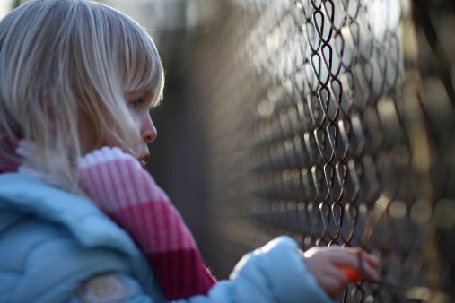 Sad girl by fence