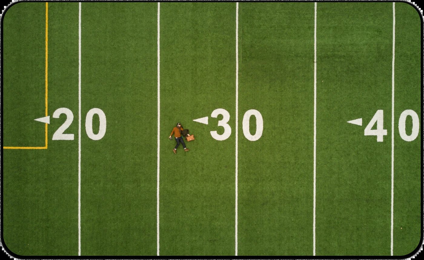 Person lying on a sports field symbolizing balance, reflection, and aging gracefully with wisdom.