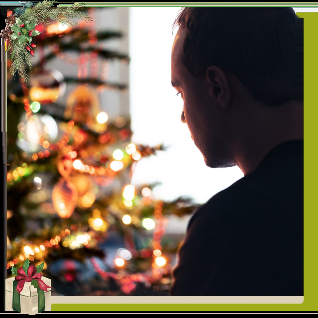 Man sitting alone in front of Christmas Tree