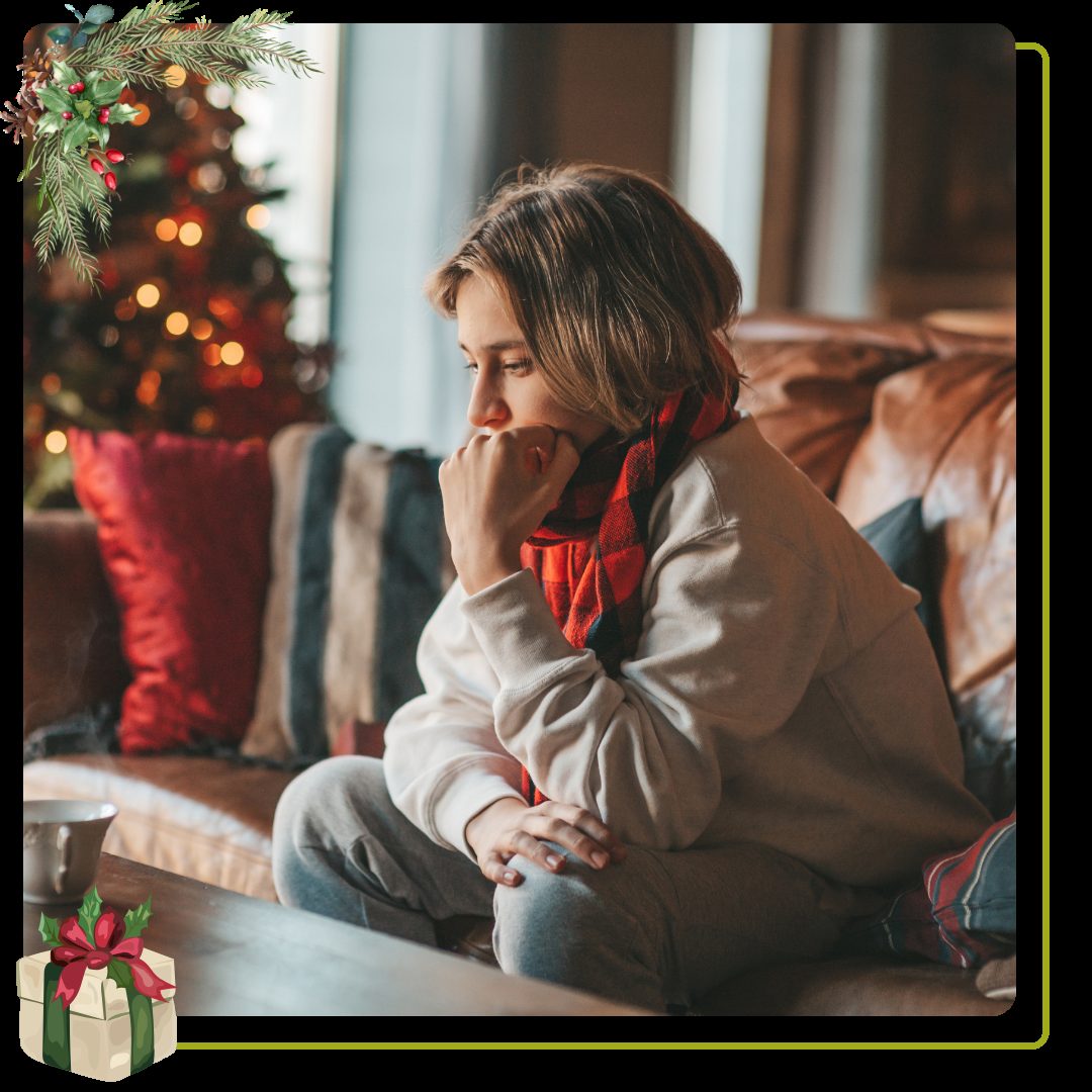Person sitting alone in front of christmas tree
