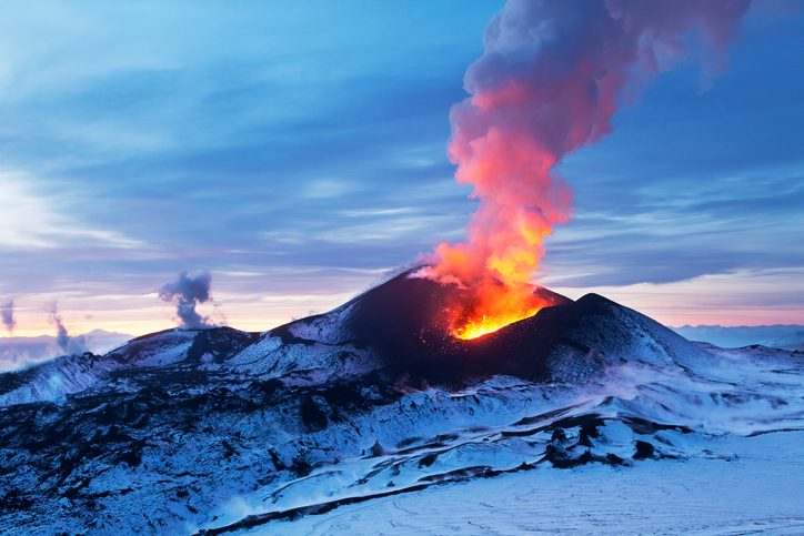 Volcano on snowy mountain beginning to erupt