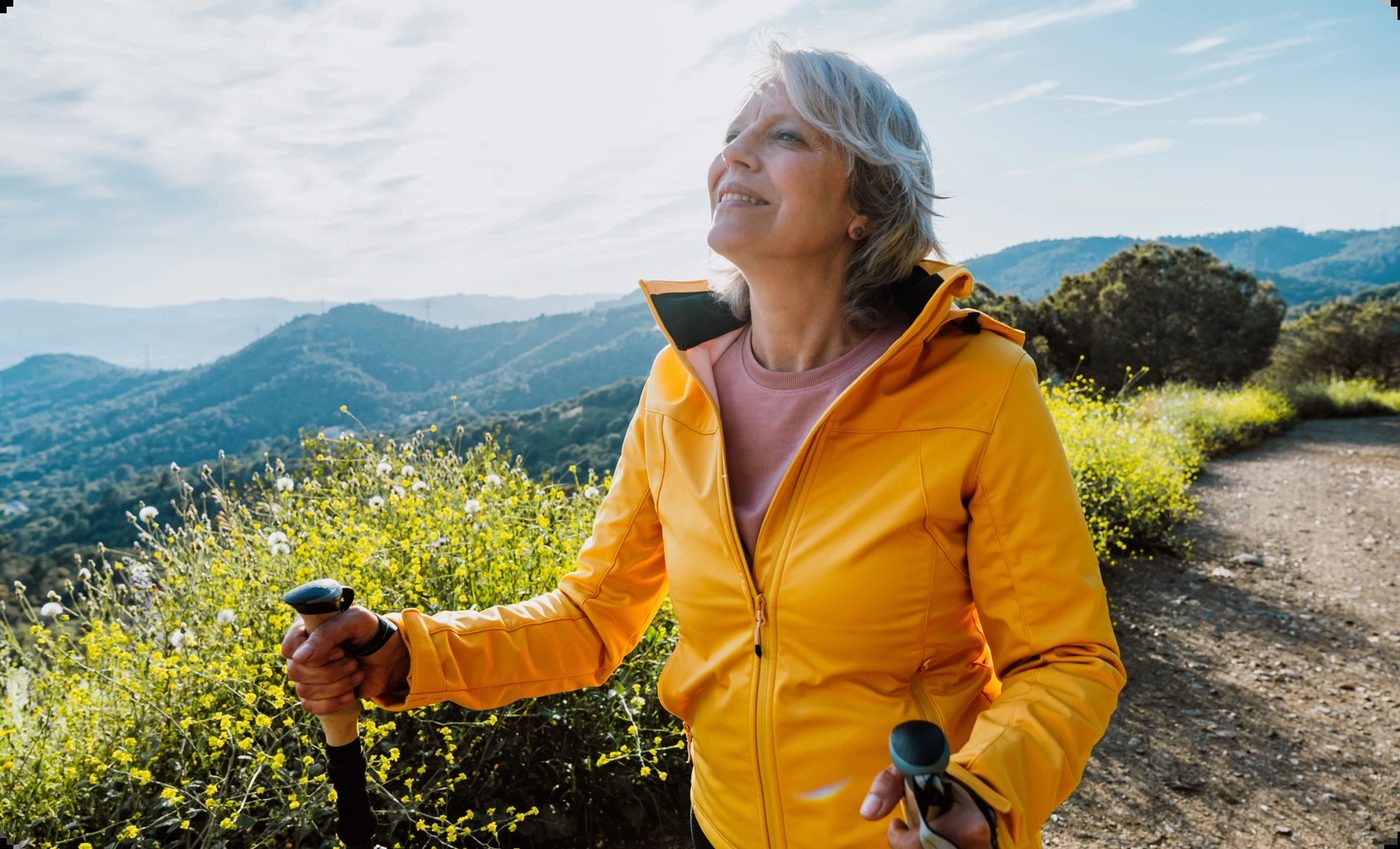A woman hiking in nature looking up with joy, representing the freedom and peace of finding closure