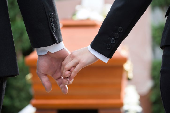 People at funeral consoling each other