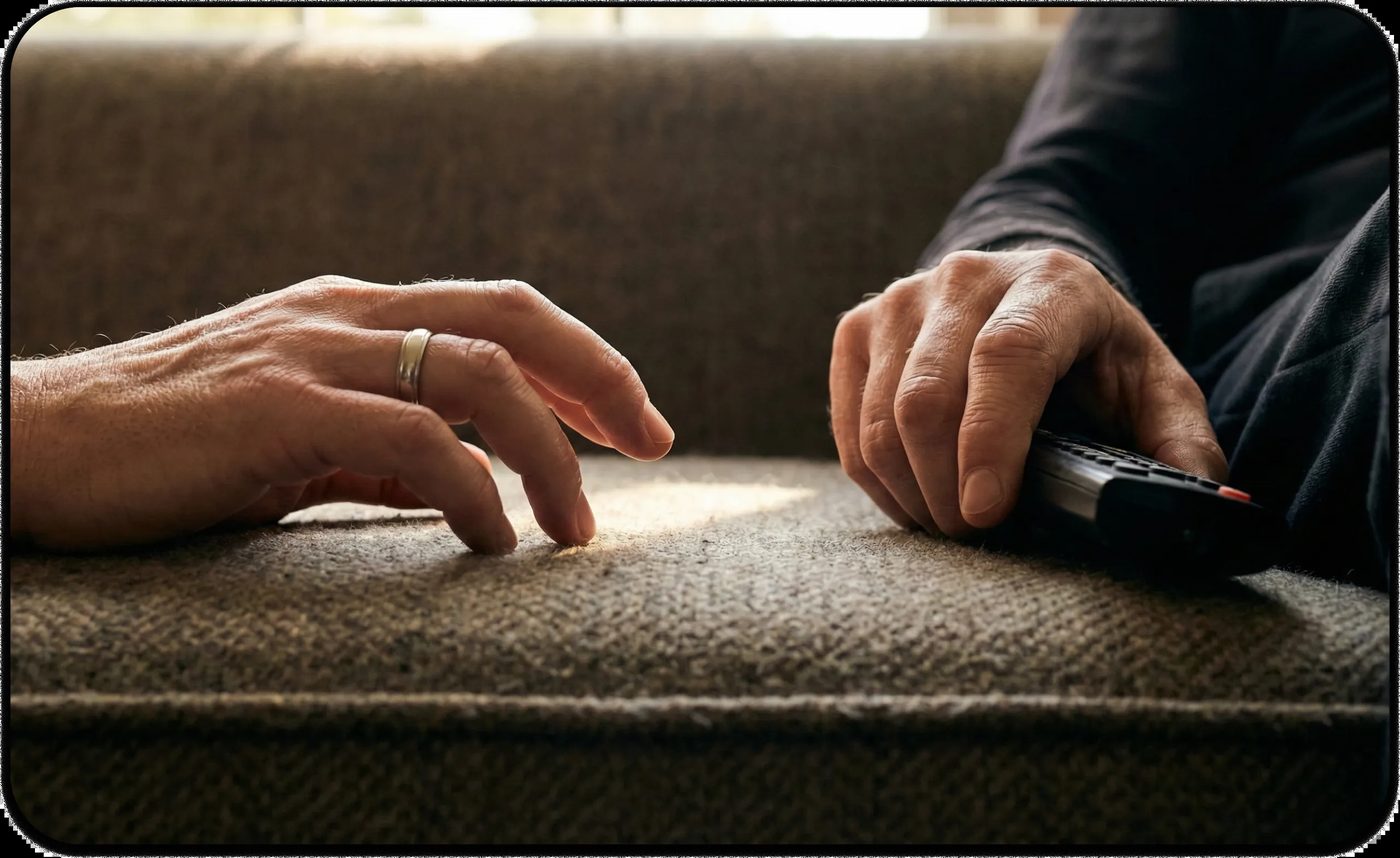 Two hands rest on a couch with space between them, symbolizing emotional distance and feeling lonely in a relationship.