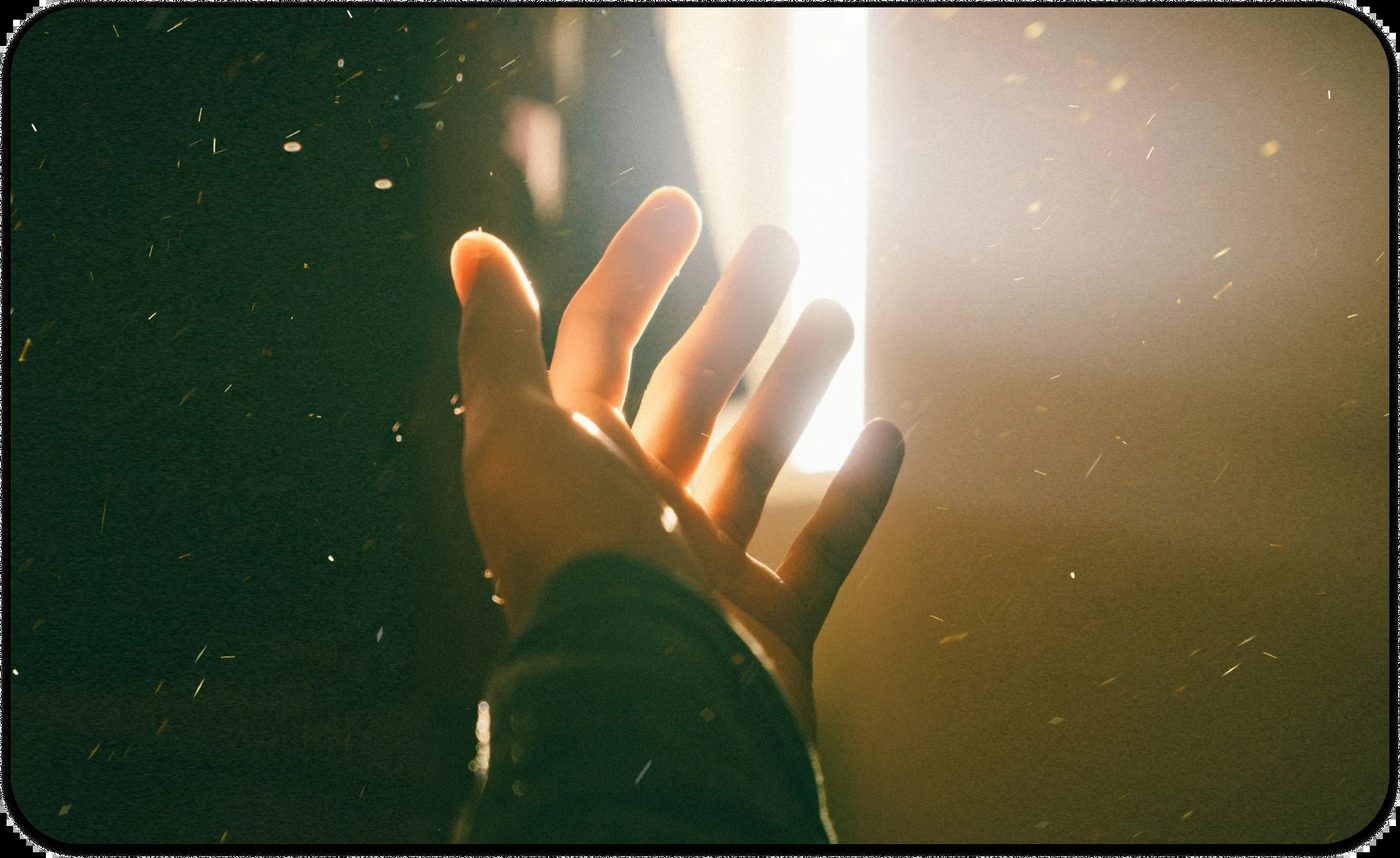 Hand reaching toward a bright light symbolizing hope and healing in suicide prevention.
