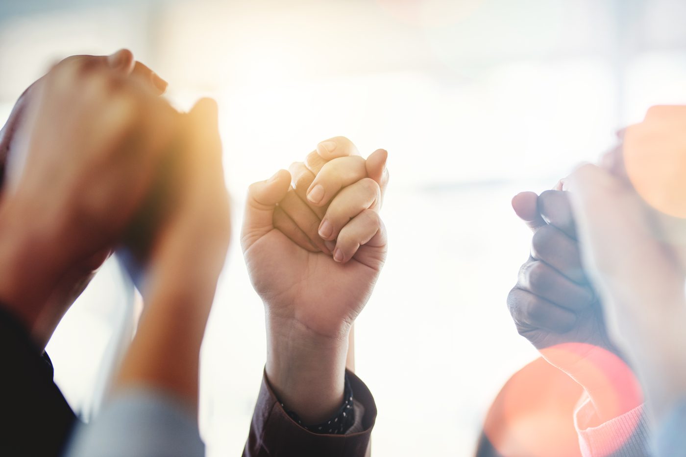 Closeup of hands held high
