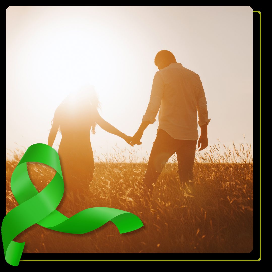 silhouettes of a couple holding hands looking at the bright sunset in a wheat field.
