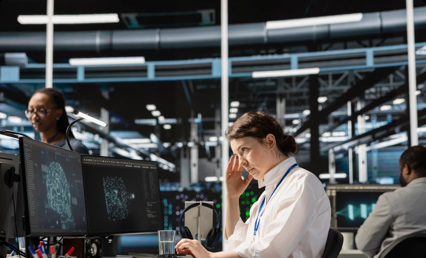 Female AI engineer experiencing stress and anxiety while working in a busy tech hub environment