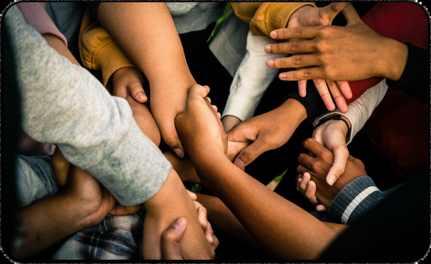 Close-up of diverse hands holding, symbolizing people pleasing behavior and the need for boundaries.