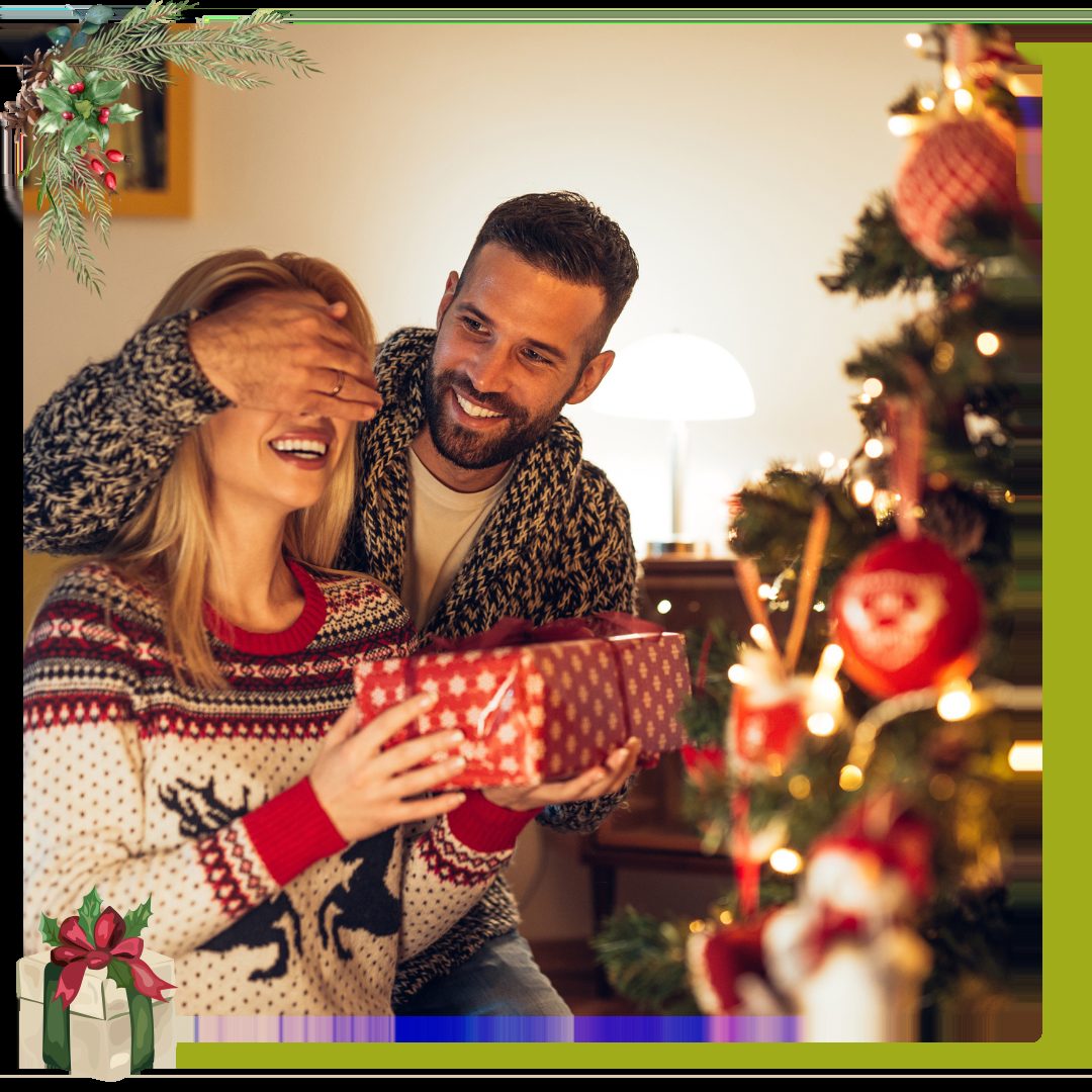 couple giving eachother a gift next to Christmas Tree