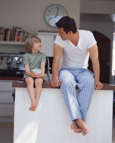 Father and son sitting on kitchen counter