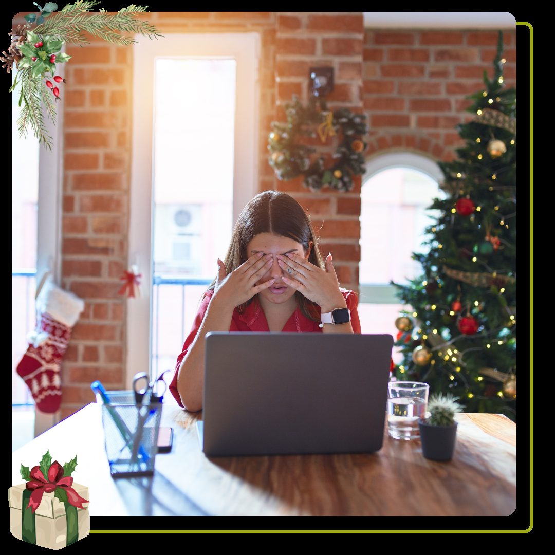 woman sitting at the table working with laptop at home around christmas tree