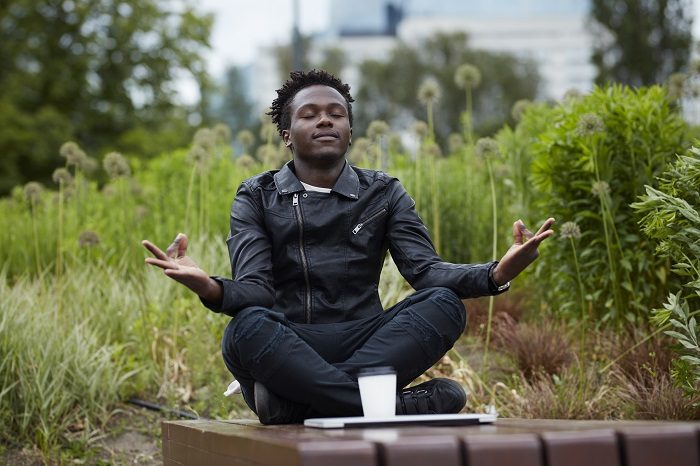 Man sitting near bench at a park, meditating