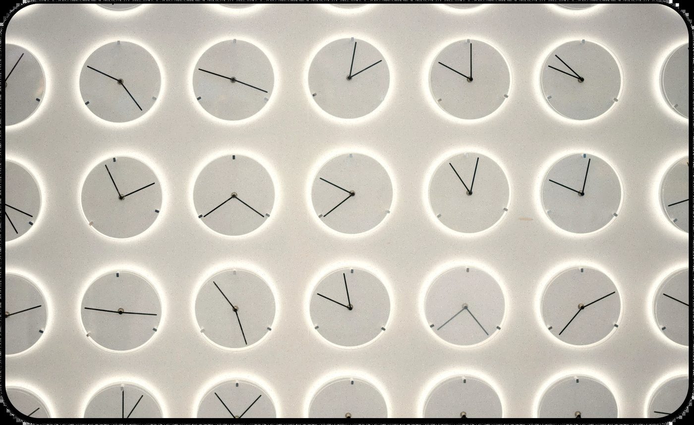 Wall of clocks showing different times, reflecting how to stop procrastinating by managing time effectively.