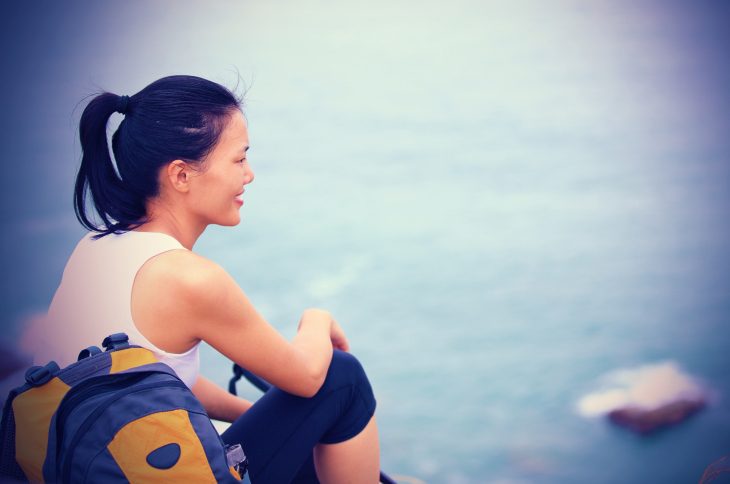 young asian woman hiker sit mountain rock