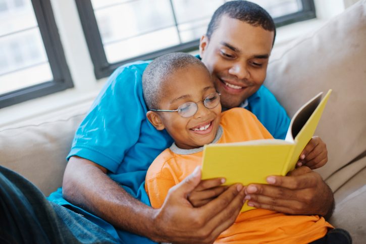 Father and son reading together