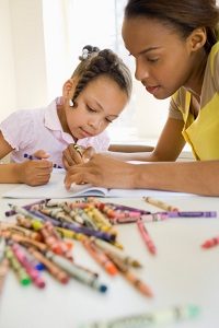 Mother and daughter coloring with crayons