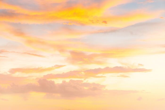 Light orange sunrise with wispy clouds