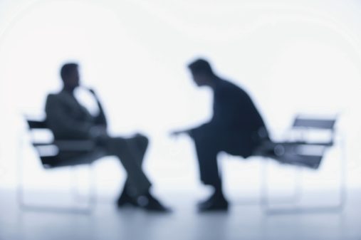 Two businessmen talking seriously, blurred focus
