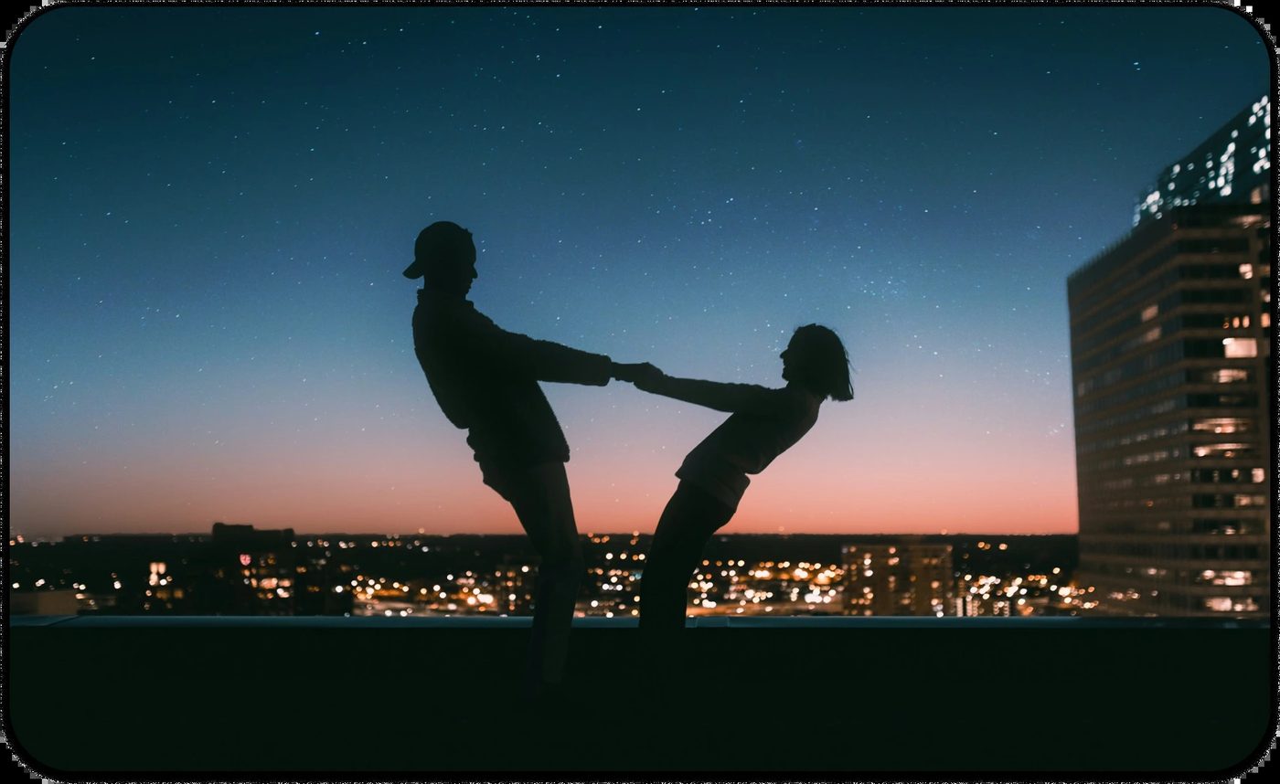 Silhouette of a couple leaning on each other's hands at sunset, symbolizing codependency in relationships