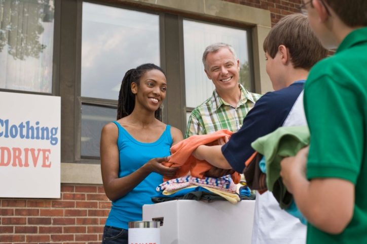 Adults and children volunteering at clothing drive